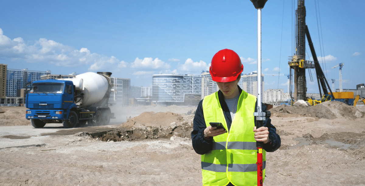Bauarbeiter nutzt Firmenhandy auf der Baustelle